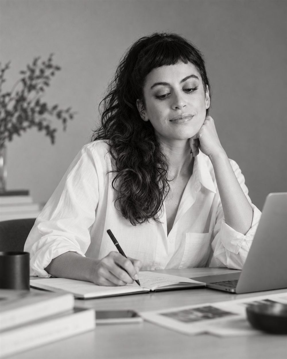 Camila Melo writing in a notebook at her desk