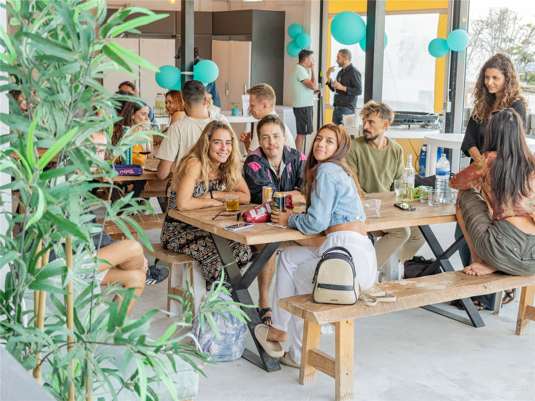 Guests sharing a meal on a sunny terrace at a Nest hostel